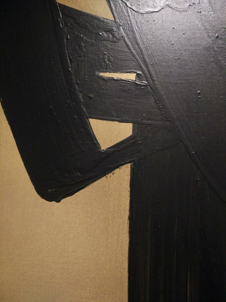 Traces de peinture noire sur un fond ocre/doré