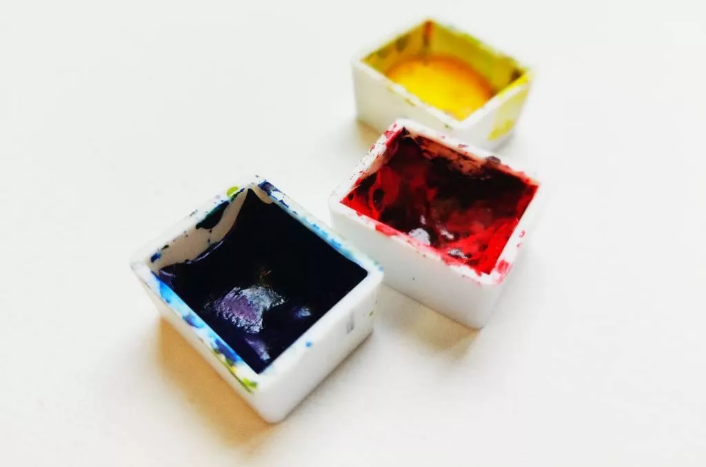 Trois godets d'aquarelle : bleu, rouge et jaune