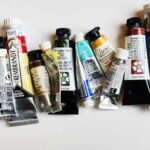 Tubes d'aquarelle de différentes marques, couleurs et contenance les unes à côté des autres