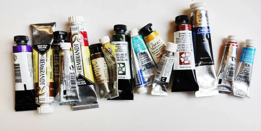 Tubes d'aquarelle de différentes marques, couleurs et contenance les unes à côté des autres