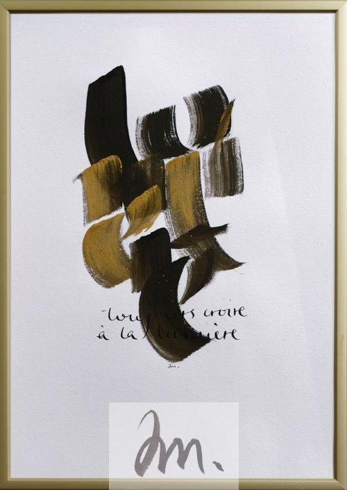 Calligraphie noire et or sur papier blanc. On devine des lettres mais pas les mots