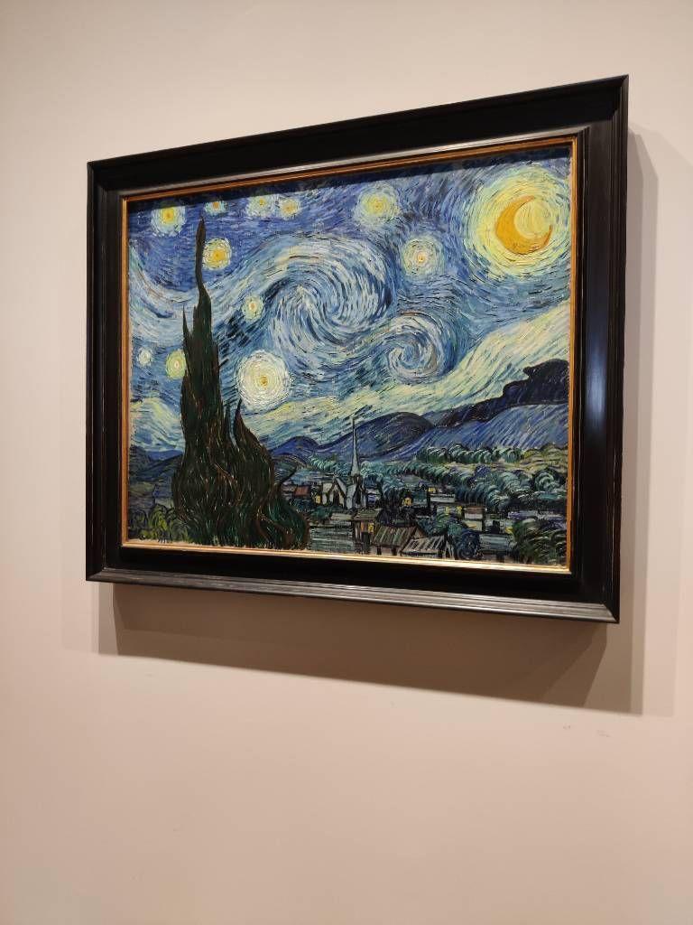 Paysage représentant un village endormis, des cyprès, mais surtout un ciel mouvementé avec une lune et des étoiles brillantes (Photo un peu en biais)