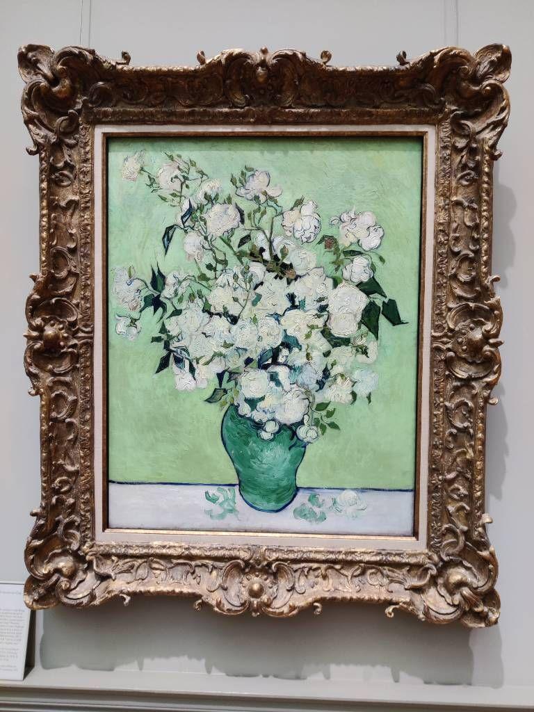 Bouquet de roses blanches dans un vase vert sur un fond vert clair