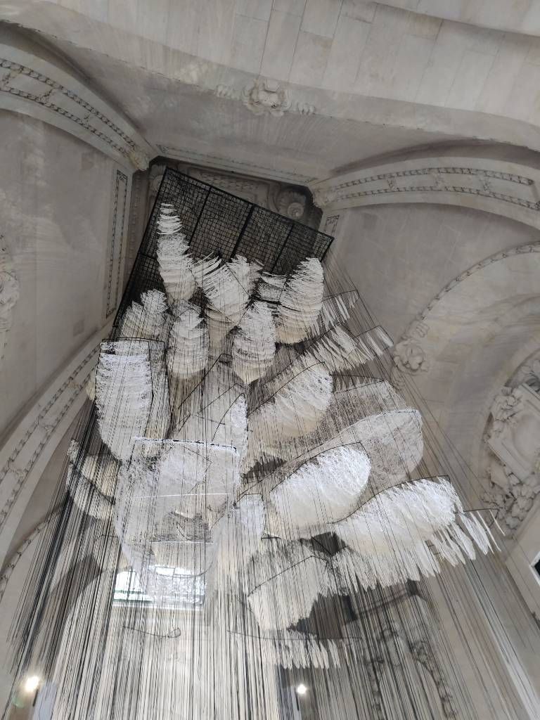 Installation de fils blancs en forme de barques suspendue à un des plafonds du Grand Palais
