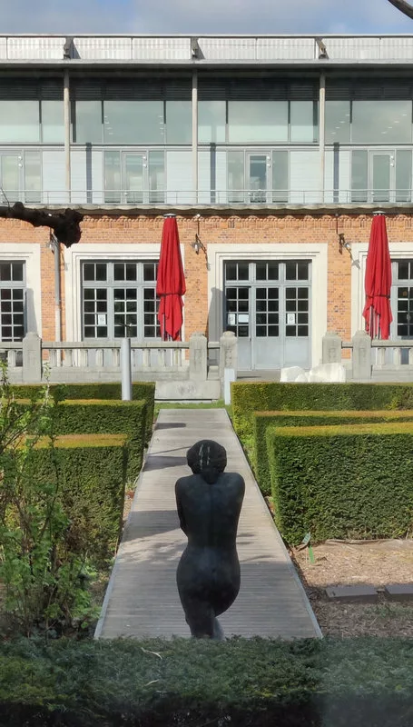 Une sculpture d'une femme de dos dans un jardin