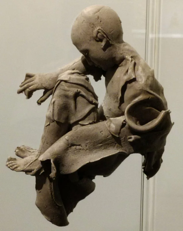 Sculpture d'un personnage chauve assis
