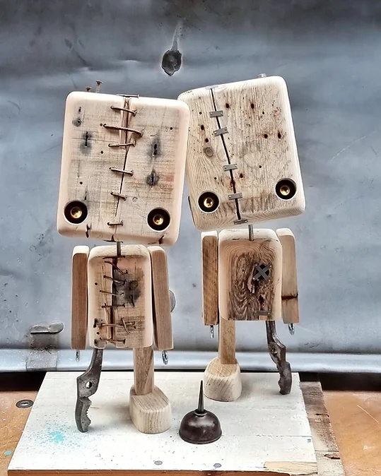 Deux robots fait de pièces assemblées de bois et de métal