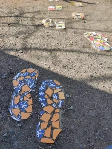 Traces de pas en mosaïque au sol sur un chemin en terre