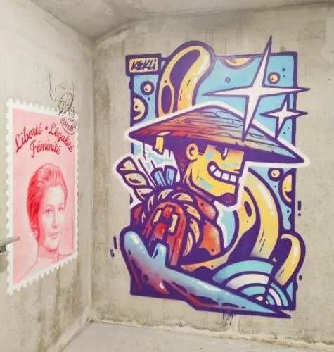 Un graff occupant tout un mur représentant un personnage avec un chapeau "chinois"
