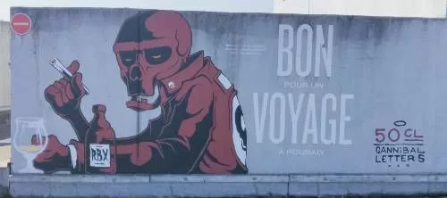 Tag d'un personnage avec une tête ressemblant à un crâne, un blouson, une bouteille (de bière ?) marquée "RBX" et une cigarette à la main. En gros "Bon voyage" mais si on lit les petits caractères cela donne "Bon pour un voyage à Roubaix" "50 cl - Cannibal letters"
