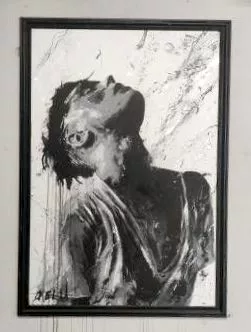 Comme un tableau, avec une baguette collée sur le mur, un dessin d'un jeune homme tête renversée