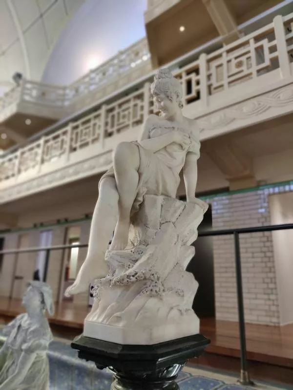 Sculpture représentant une jeune fille comme assise au bord de l'eau et tenant un tissu sur sa poitrine