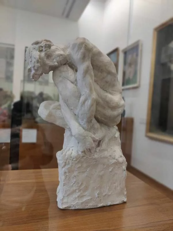 Sculpture d'une personne accroupie et repliée sur elle-même