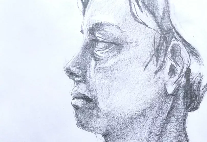 Gros plan sur une tête de profil au crayon. Les ombres sont faites au niveau du visage mais les cheveux