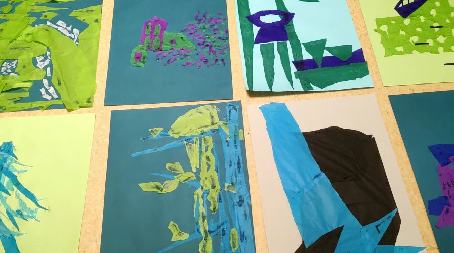 Un ensemble de feuilles de couleurs avec des composition au papier déchiré dessus posé au sol