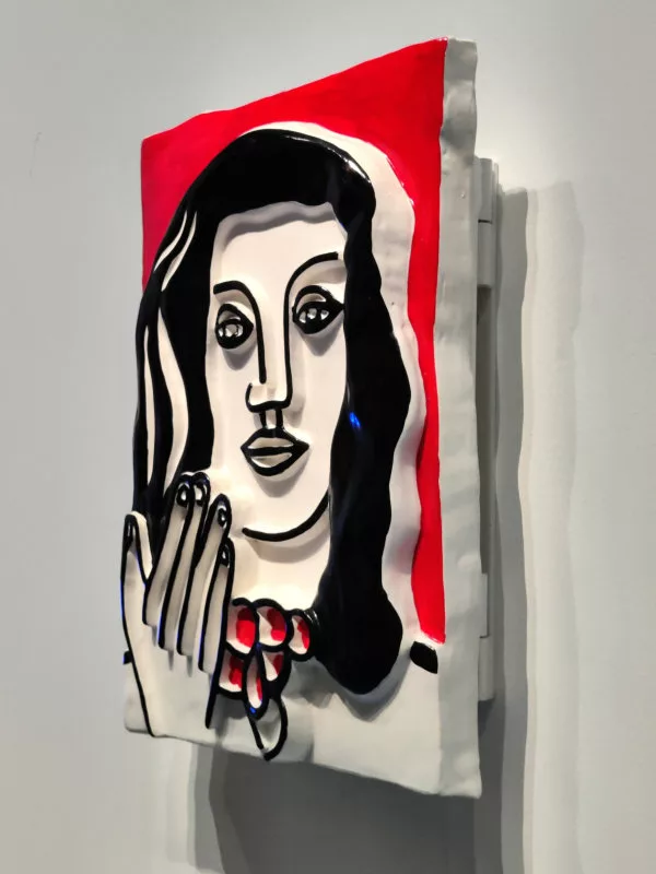 Un bas relief vu de côté représentant une femme et sa main. Il n'y a que trois profondeurs : le fond, le corps et en surface les cheveux et les arrêtes du dessin