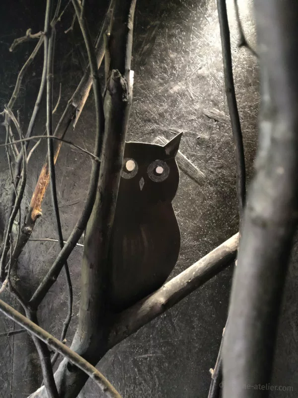 Un hibou en carton dans une décor tout en noir