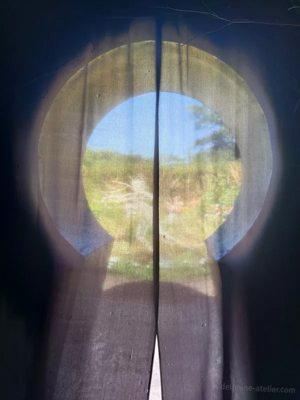Une porte d'entrée en forme de trou de serrure dissimulée par un voile