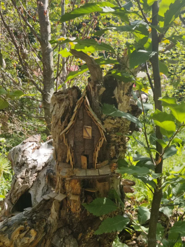 Une petite maison faite de bois sur une souche de bois