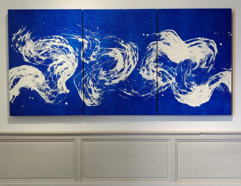 Trace sinueuse de peinture blanche sur un fond bleu, tableau en trois panneaux