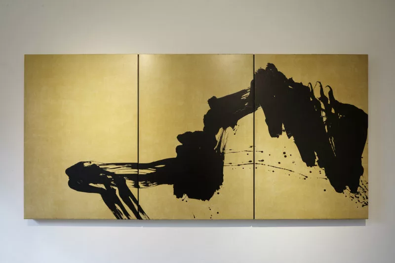 Une trace de peinture noire sur un fond doré (trois panneaux)