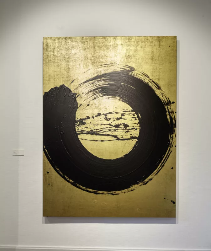 Un épais cercle noir à la peinture fait d'une trace sur un fond doré