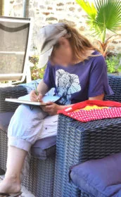 Une femme en train de dessiner au crayon de couleur dans un carnet