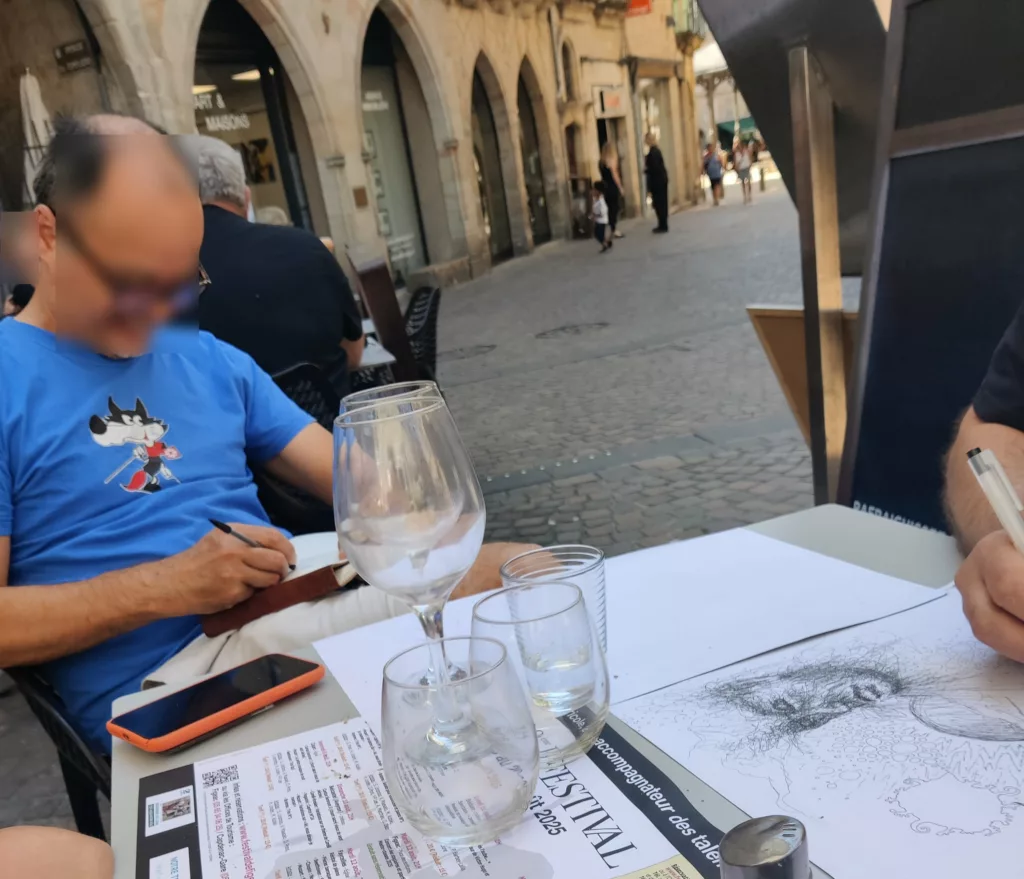 Deux personnes attablées en train de dessiner