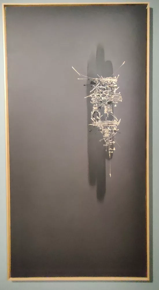 Tableau abstrait sur fond noir avec une zone réduite accueillant des traces blanches sur un fond