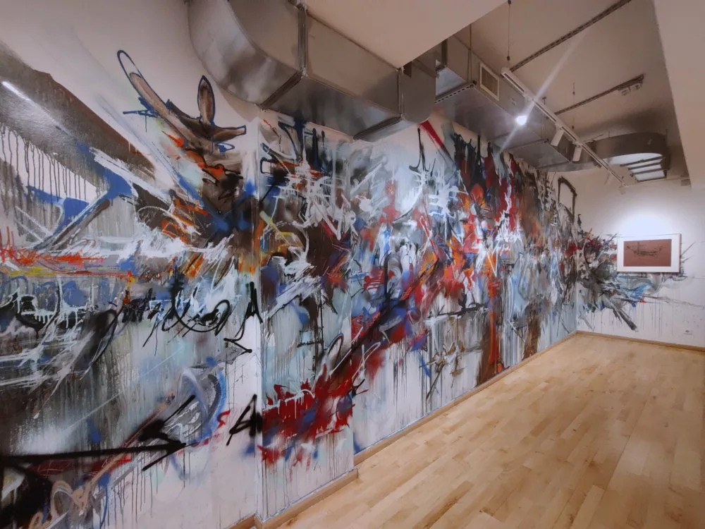 Un mur taggé façon Georges Mathieu donnant sur un tableau de Georges Mathieu