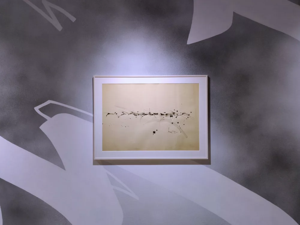 Un tableau de Georges Mathieu sur un mur taggé qui reprend des traces, un peu calligraphiques, du même esprit que le tableau