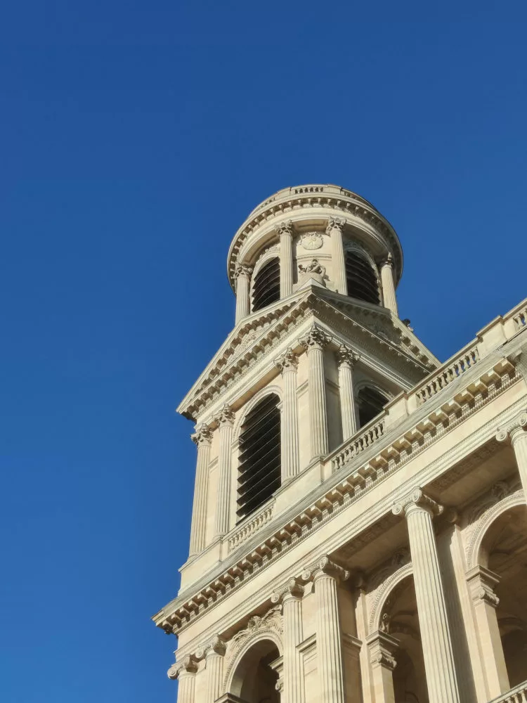 Vue extérieure : une tour d'église se détache nettement d'un ciel bleu uni