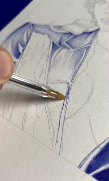 Gros plan sur un dessin en train de se faire : le sujet a d'abord été tracé au crayon et on voit qu'il est en train d'être colorié au stylo bille