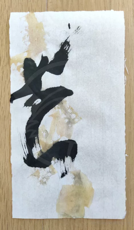 Une trace à l'encre noire qui ressemble à un idéogramme chinois et à la peinture dorée