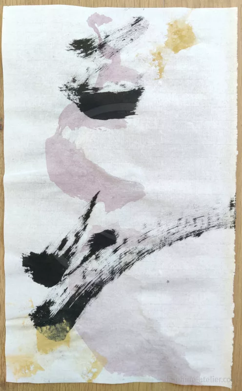 Des traces à l'encre noire et à la peinture dorée et rose