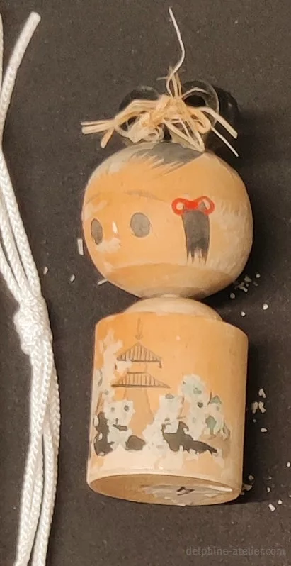 Une petite poupée japonaise en bois très abîmée