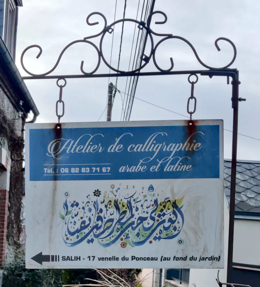 Panneau en métal dans la rue indiquant un atelier de calligraphie