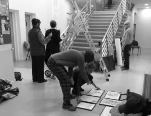 Une pièce avec un grand escalier où des personnes commente un essai d'affichage mis au sol