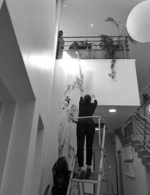 Des personnes en train d'accrocher une longue fresque verticale