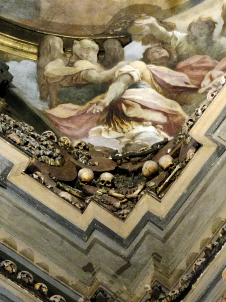 Photo d'un détail architectural où on voit une fresque des des ossements agencés en décoration