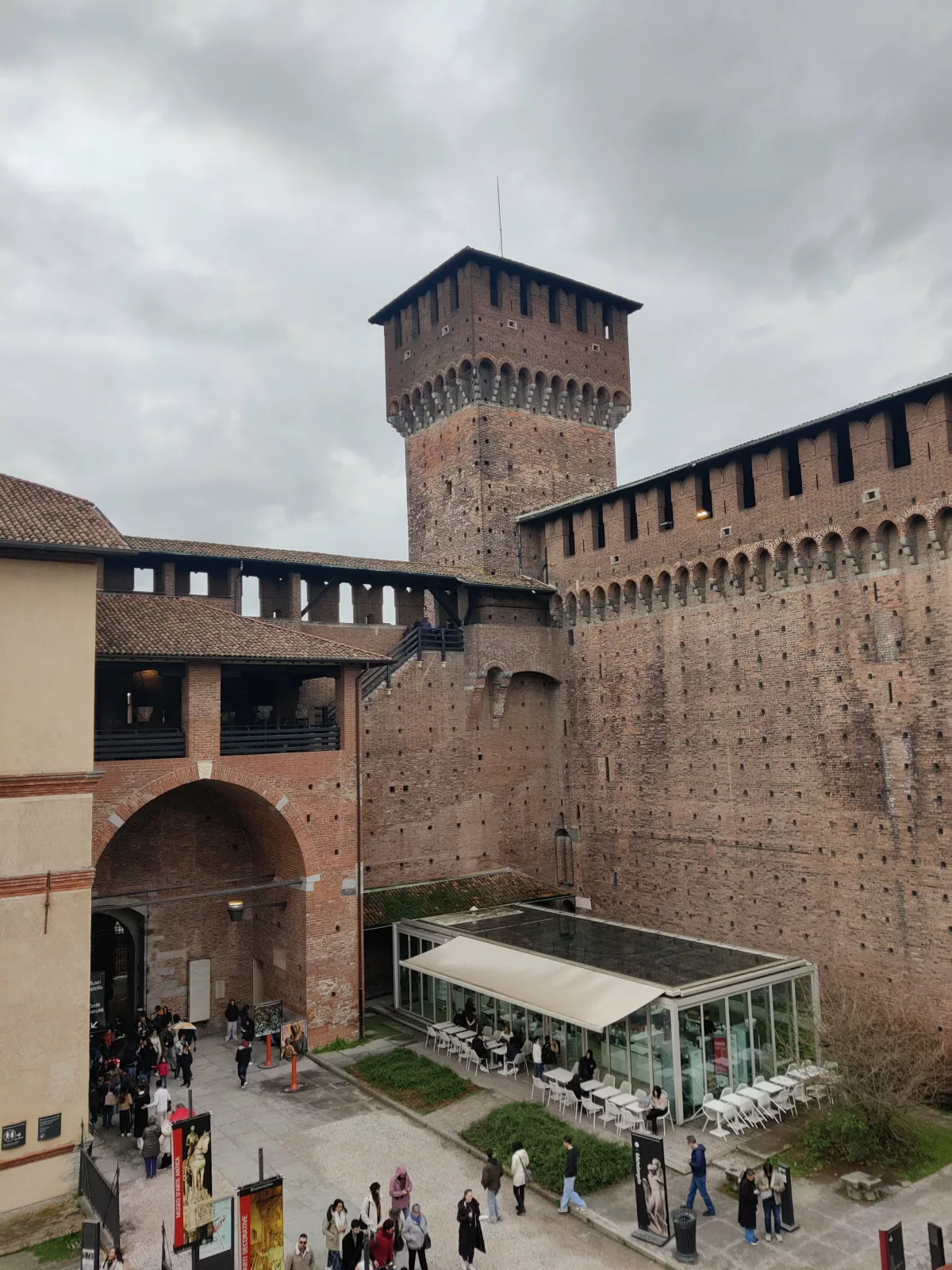 Un palais en briques rouges avec une tour dont la partie supérieure est plus large