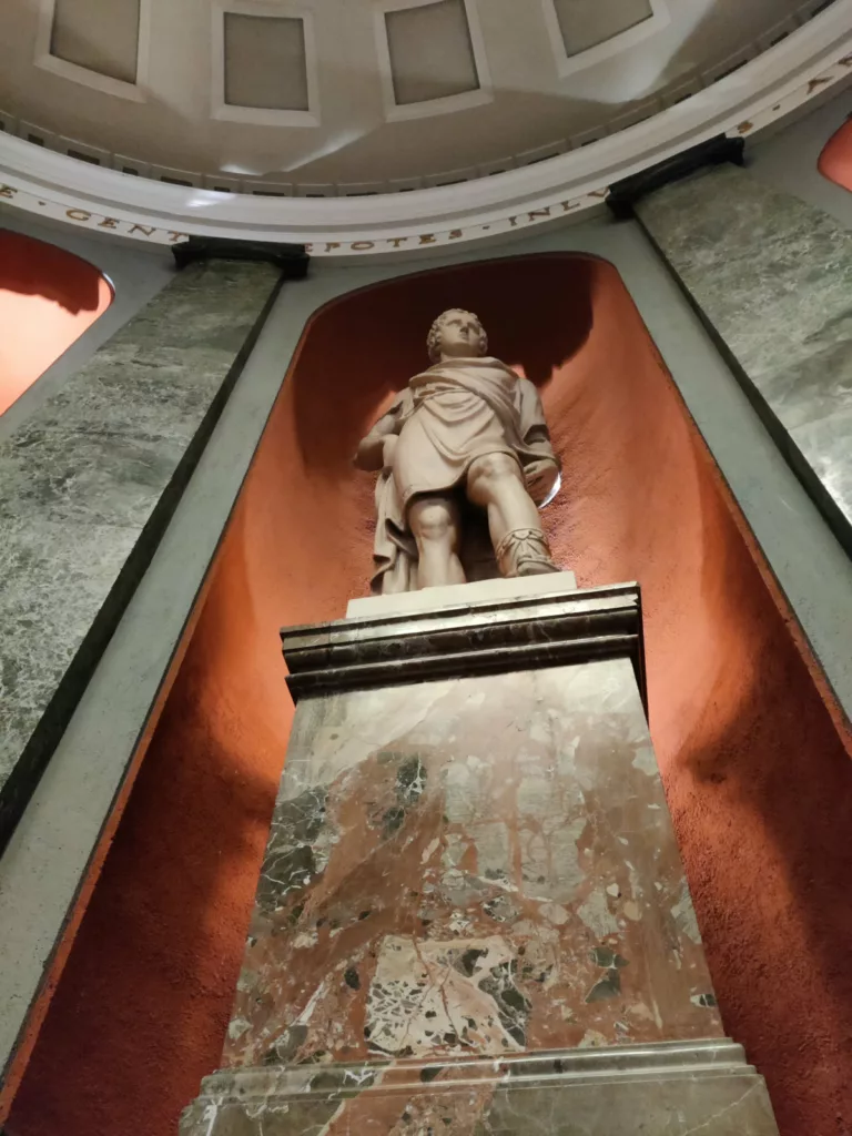 Sculpture d'un homme sur un socle vue en forte contre-plongée