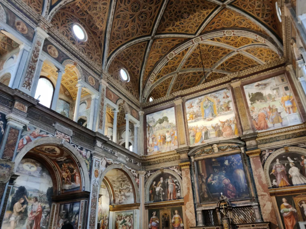 Intérieur d'une église recouverte de fresques (figuratives sur les murs, ornementale sur le plafond