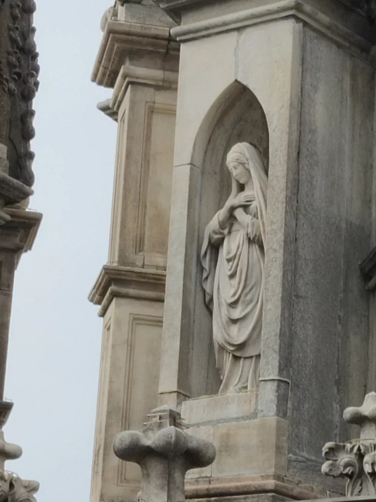 Une sculpture d'une femme en recueillement dans une niche