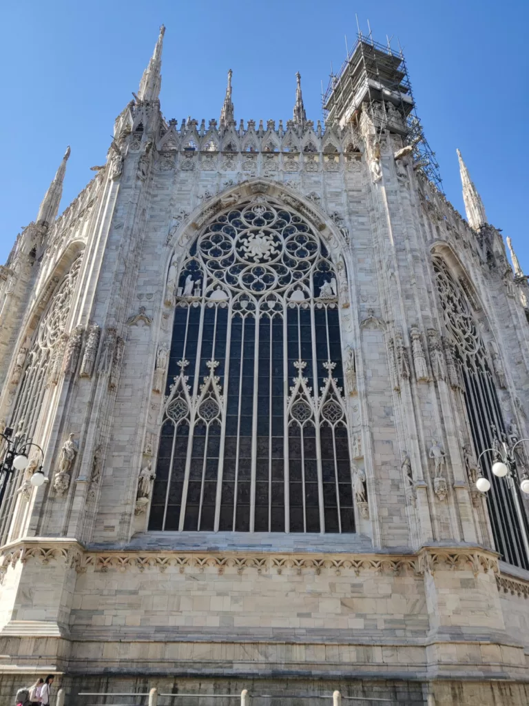 Extérieur d'une grande église richement décorée ; vue sur un grand vitrail