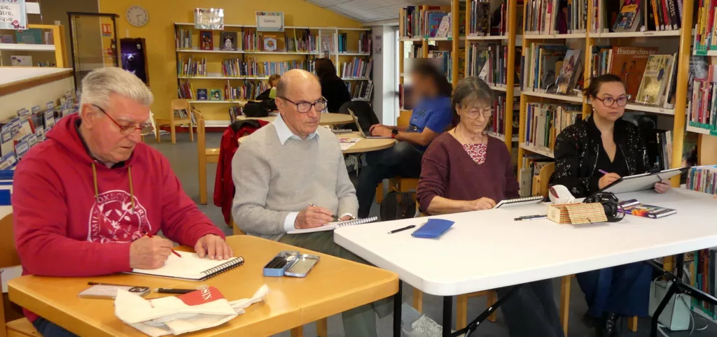 Quatre dessinateurices en train d'observer leur modèle