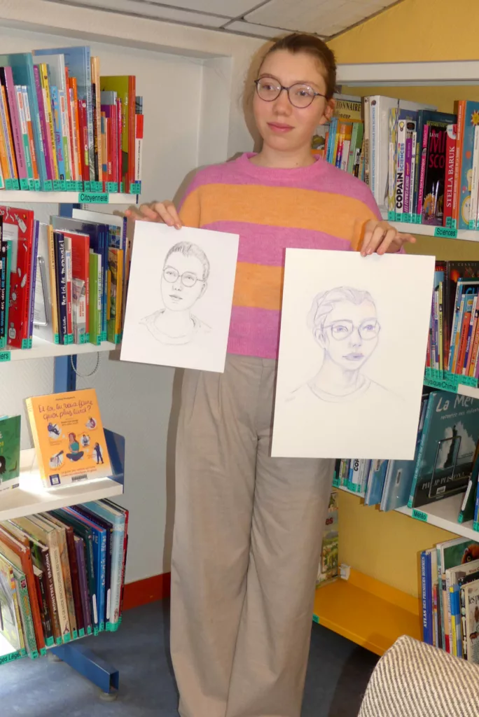 Une jeune fille en train de porter devant elle deux feuilles avec des portraits d'elle au crayon
