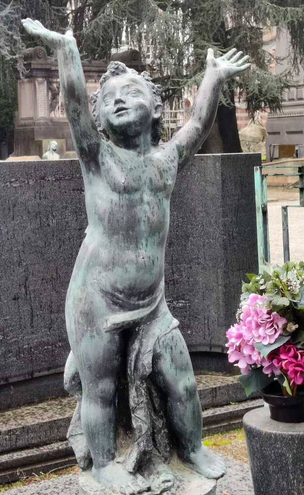 Sculpture dans un cimetière d'un enfant joyeux