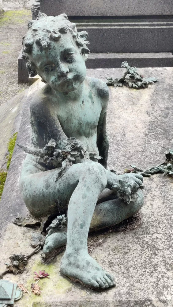 Tombe avec une sculpture représentant un enfant boudeur