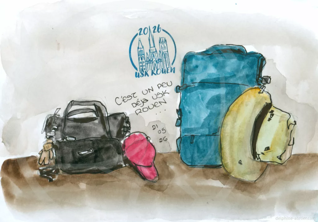 Croquis au feutre noir et à l'aquarelle montrant des bagages avec une inscription "C'est déjà un peu USK Rouen 21 05 25" + un tampon "2026 USK Rouen"